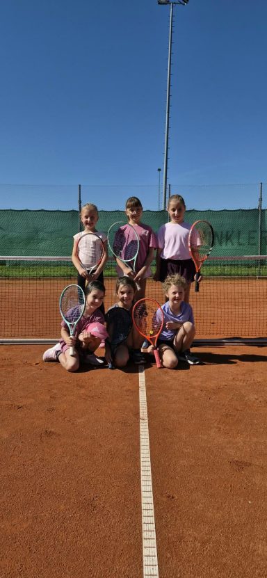 Kinder mit Tennisschlägern auf dem Tennisplatz