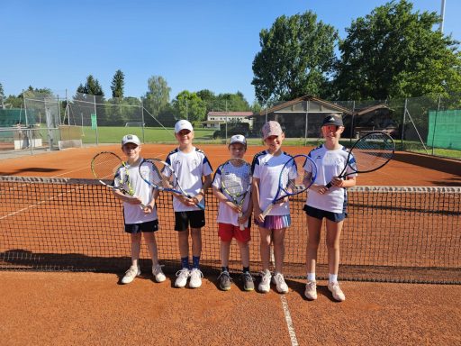 Kinder mit Tennisschlägern auf dem Tennisplatz