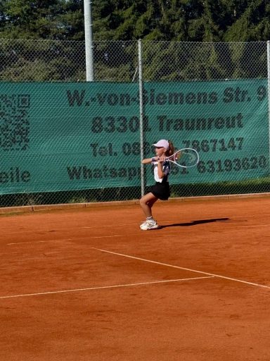 Mädchen spielt Rückhand auf dem Tennisplatz