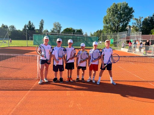 Kinder mit Tennisschlägern auf dem Tennisplatz