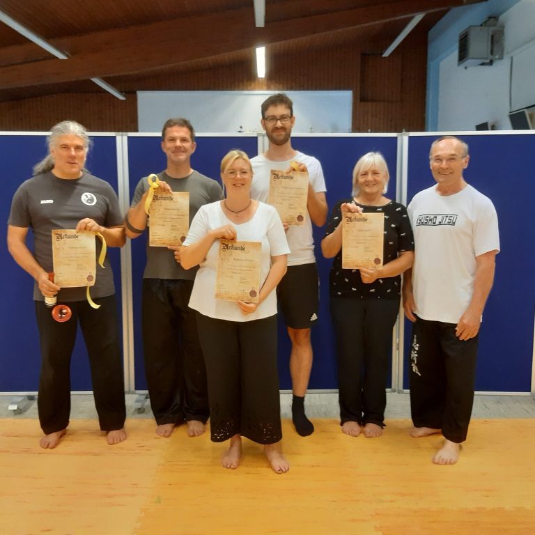 Die Lehrgangsteilnehmer mit ihren Urkunden Gruppenfoto von sechs Personen mit Urkunden in einer Sporthalle.